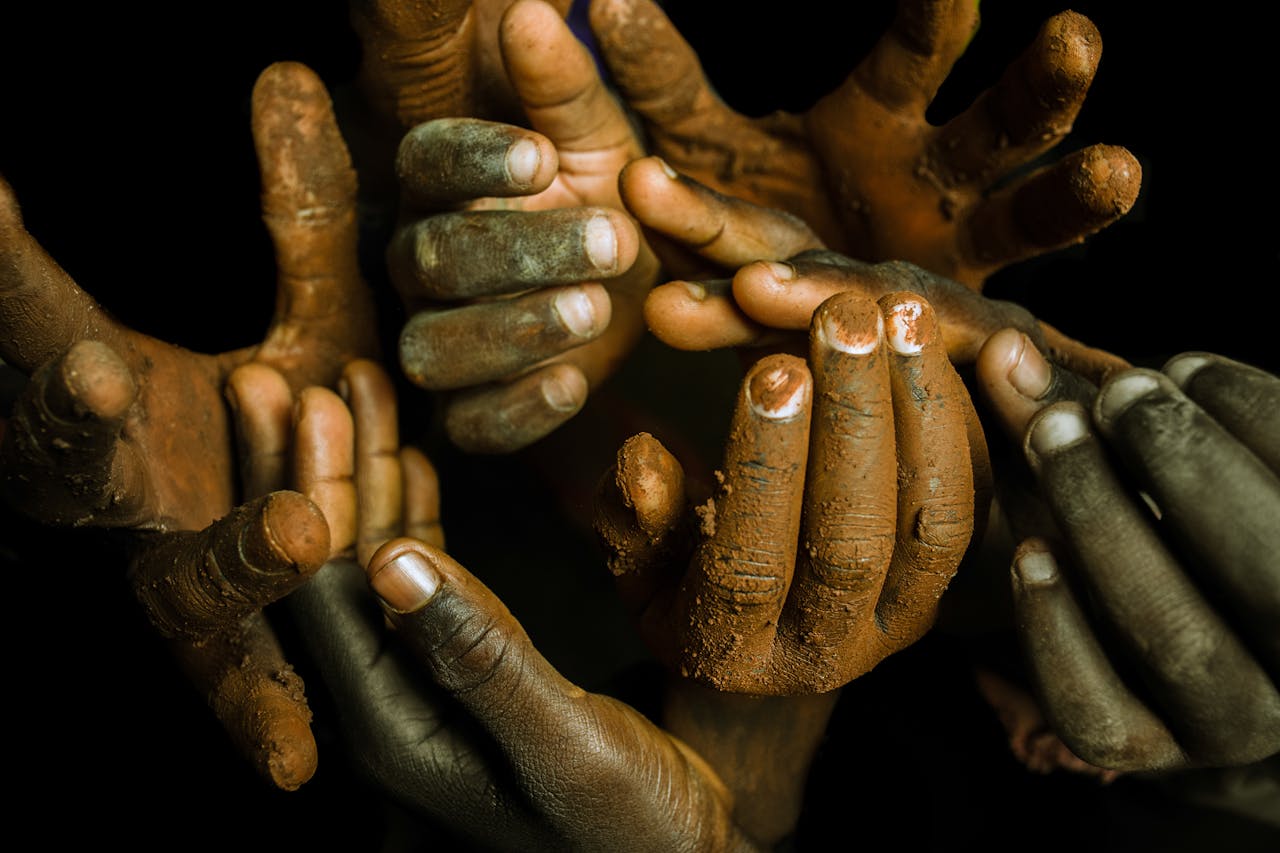 client-stories-img A creative close-up of muddy hands, depicting unity and diversity in an artistic arrangement.